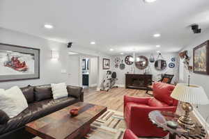 Living room featuring recessed lighting, light wood-style floors, and a chandelier