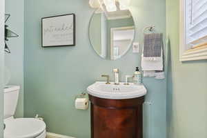 Half bathroom featuring vanity and toilet