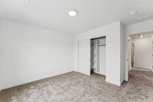 Unfurnished bedroom with carpet and a closet
