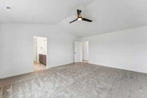 Empty room featuring a ceiling fan, light carpet, and lofted ceiling