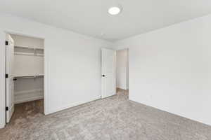 Unfurnished bedroom with carpet floors and a walk in closet