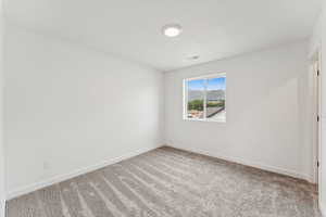 Carpeted empty room featuring baseboards