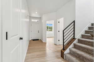 Foyer entrance featuring stairway and light wood finished floors