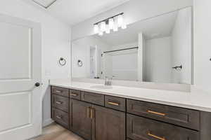 Full bathroom with vanity, wood finished floors, and a shower