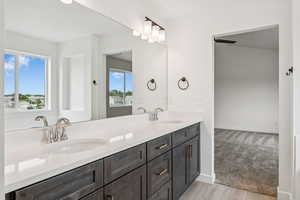 Full bathroom with double vanity and wood finished floors