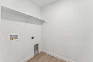 Laundry area featuring hookup for a washing machine, light wood-style floors, and electric dryer hookup