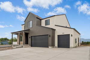 View of front of property with concrete driveway and a garage