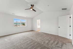 Empty room featuring carpet, ceiling fan, and vaulted ceiling