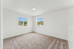 Carpeted spare room with baseboards