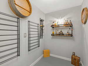 Hallway with baseboards and finished concrete flooring