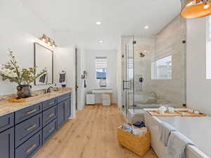 Full bathroom featuring vanity, a freestanding tub, a stall shower, plenty of natural light, and recessed lighting