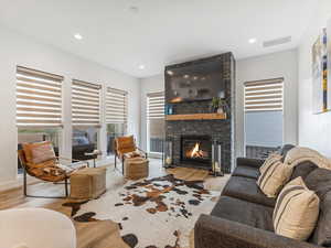 Living area with wood finished floors, a fireplace, and recessed lighting