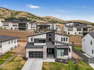 Contemporary house with a mountain view, concrete driveway, an attached garage, and a residential view