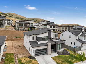 View of front facade featuring a residential view, concrete driveway, a mountain view, and a garage
