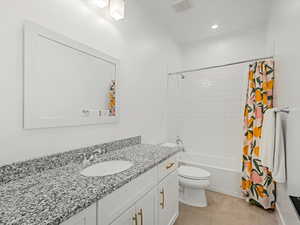 Full bathroom featuring vanity, shower / tub combo with curtain, and recessed lighting
