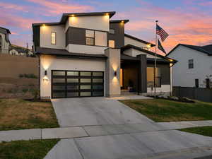 Modern home with driveway, a garage, and stucco siding