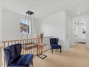 Living area featuring healthy amount of natural light, carpet, a ceiling fan, and recessed lighting