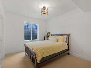 Bedroom with light colored carpet and baseboards