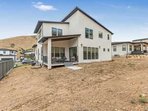 Rear view of house with stucco siding and a mountain view