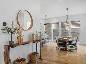 Dining room with plenty of natural light, light wood-type flooring, recessed lighting, and a chandelier