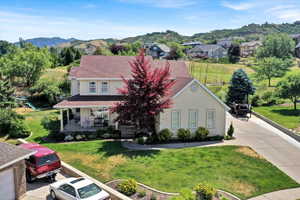 View of front of home with stucco siding, a porch, a mountain view, a front lawn, and a residential view