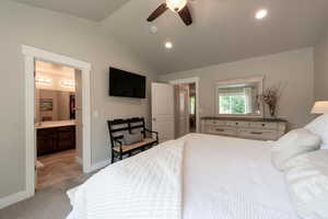Bedroom featuring light carpet, vaulted ceiling, recessed lighting, connected bathroom, and a ceiling fan