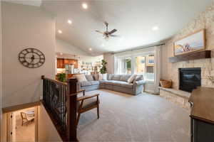 Living room featuring light carpet, ceiling fan, recessed lighting, a fireplace, and lofted ceiling