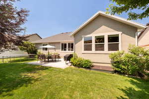 Back of property with a patio area, stucco siding, a lawn, and a trampoline