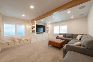 Living area with light carpet and recessed lighting