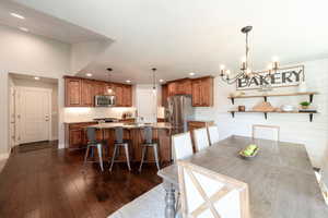 Dining room with recessed lighting, a chandelier, and dark wood-style floors