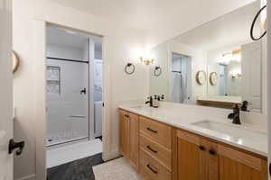 Bathroom featuring a shower stall and double vanity