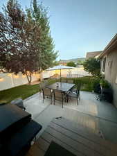Fenced backyard with a trampoline, a patio, grilling area, and outdoor dining space