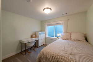 Bedroom featuring dark colored carpet and baseboards