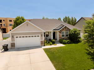 Craftsman-style house with stone siding, a garage, and driveway
