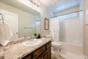 Full bathroom featuring vanity, shower / bathtub combination with curtain, and tile patterned flooring