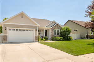 Craftsman inspired home with stone siding, a garage, and driveway