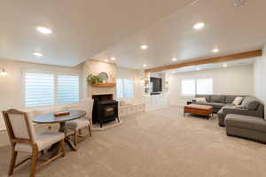 Carpeted living room with a wood stove and recessed lighting
