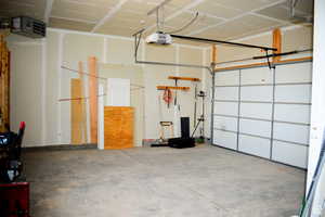 Garage featuring a garage door opener and a heating unit