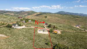 Aerial view of sparsely populated area featuring a mountain backdrop and property parcel outlined