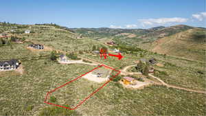 Aerial view of property's location with property parcel outlined and a mountain backdrop