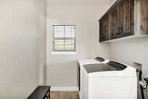 Main floor Laundry area with washer and clothes dryer and cabinet space