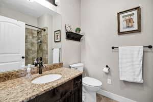 Master Bathroom with vanity, tiled shower, and tile patterned flooring