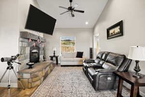 Living room featuring wood finished floors, ceiling fan, vaulted ceiling, and recessed lighting