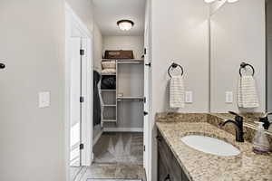 Main floor Bathroom featuring vanity and a walk in closet