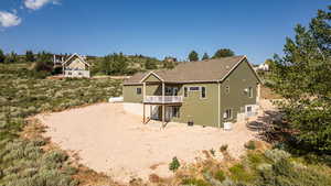 Back of house with roof with shingles and a wooden deck