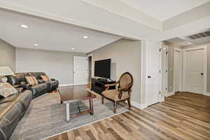 Living area with wood finished floors and recessed lighting
