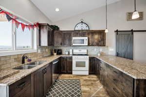 Kitchen with white appliances, dark brown cabinets, backsplash, a peninsula, and high vaulted ceiling