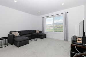 Carpeted living room with recessed lighting and baseboards