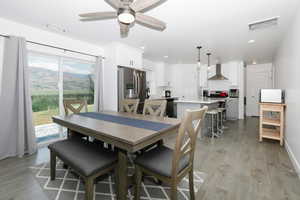 Dining room with light wood finished floors, ceiling fan, and recessed lighting