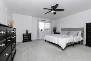 Bedroom with light colored carpet and ceiling fan